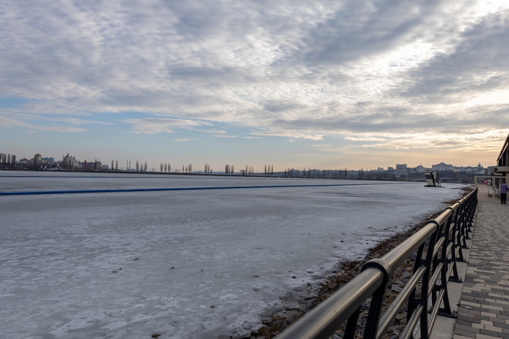 a person walking on a sidewalk next to a body of water