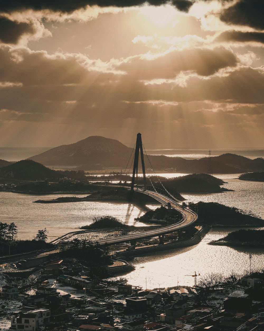 the sun shines through the clouds over a bridge