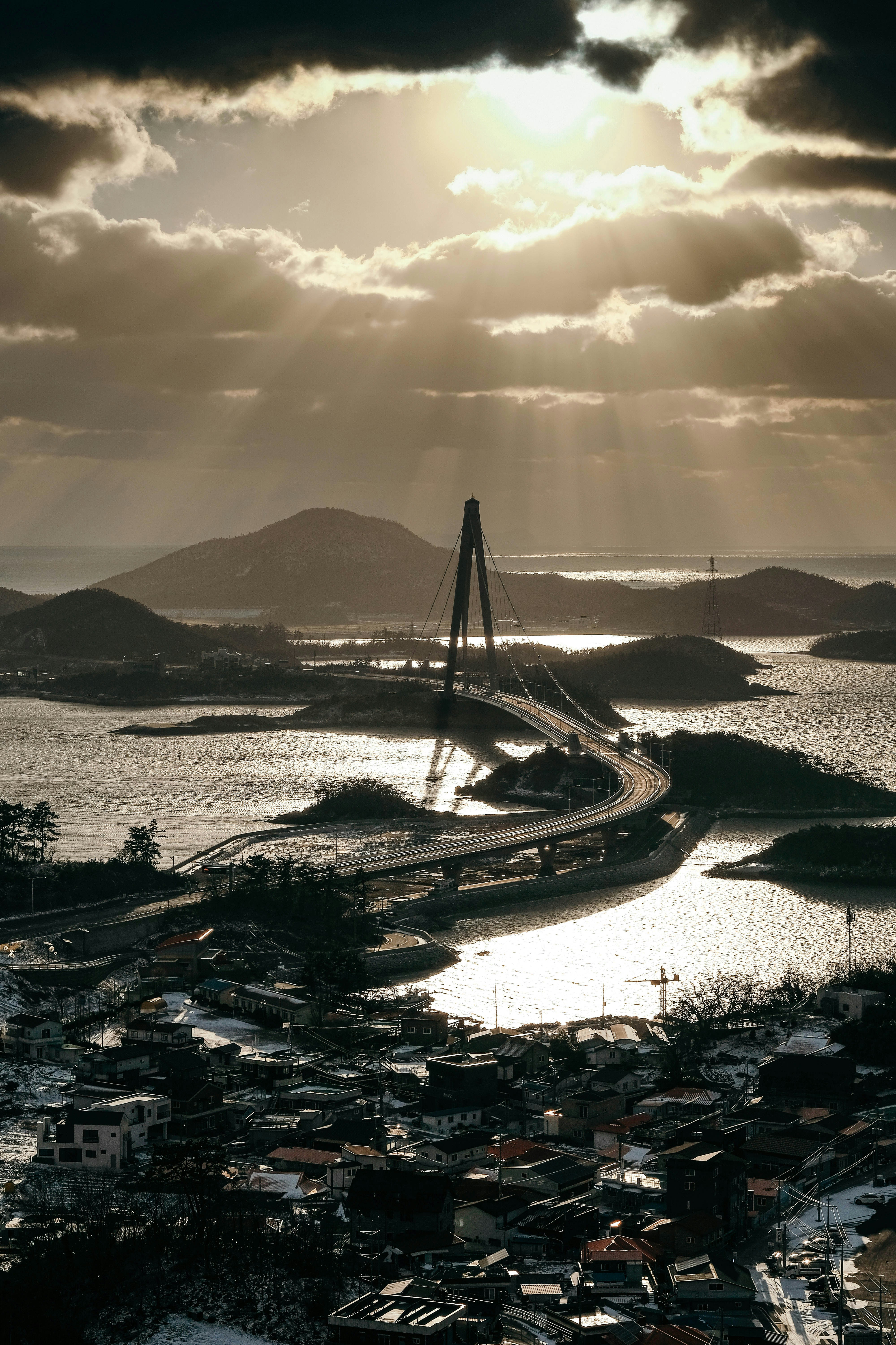 the sun shines through the clouds over a bridge