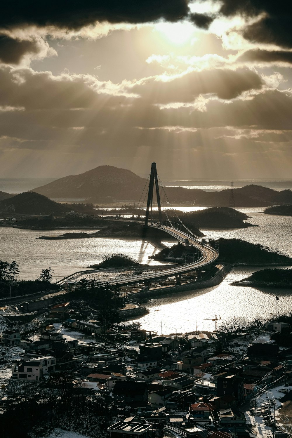 the sun shines through the clouds over a bridge