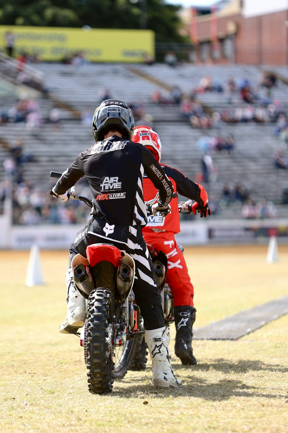 a couple of people riding on the back of dirt bikes