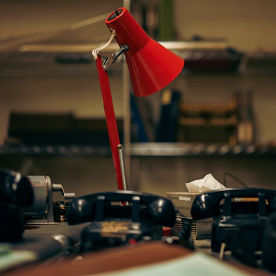a red desk lamp sitting on top of a table