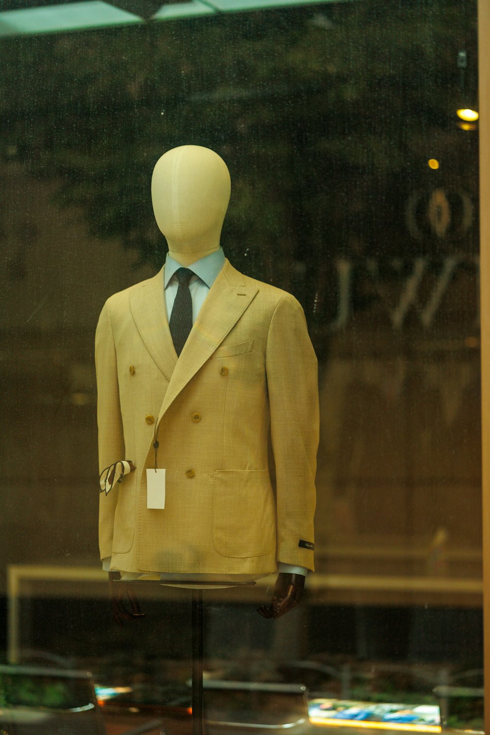a mannequin wearing a suit and tie in a window