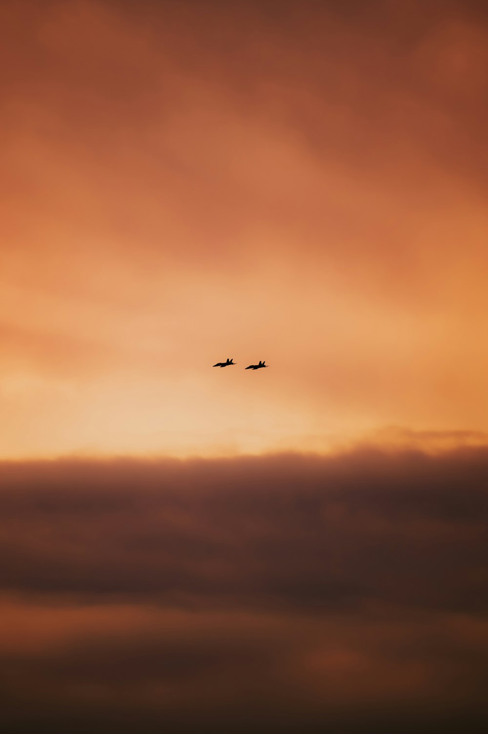 un couple d’avions volant dans un ciel nuageux