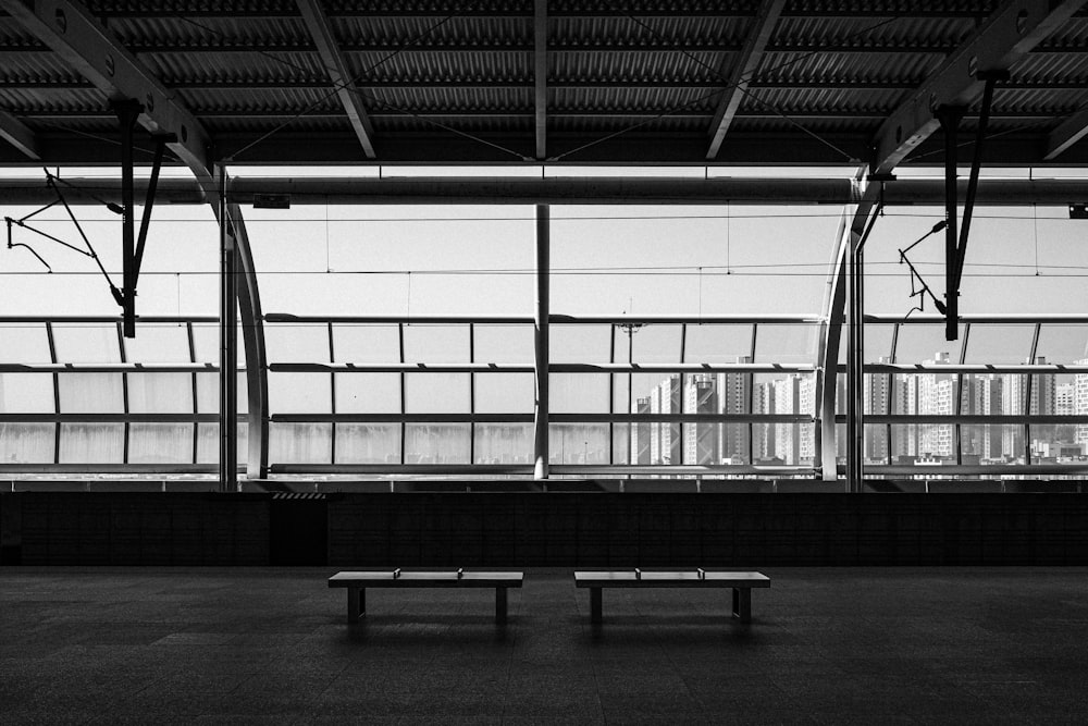a black and white photo of a bench in a building