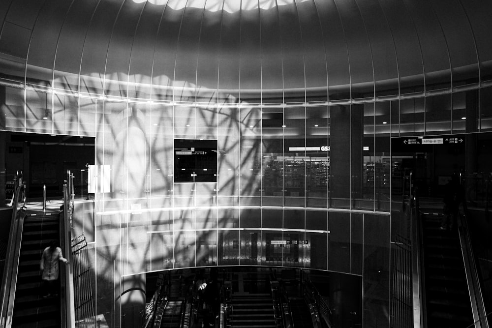 a black and white photo of an escalator in a building