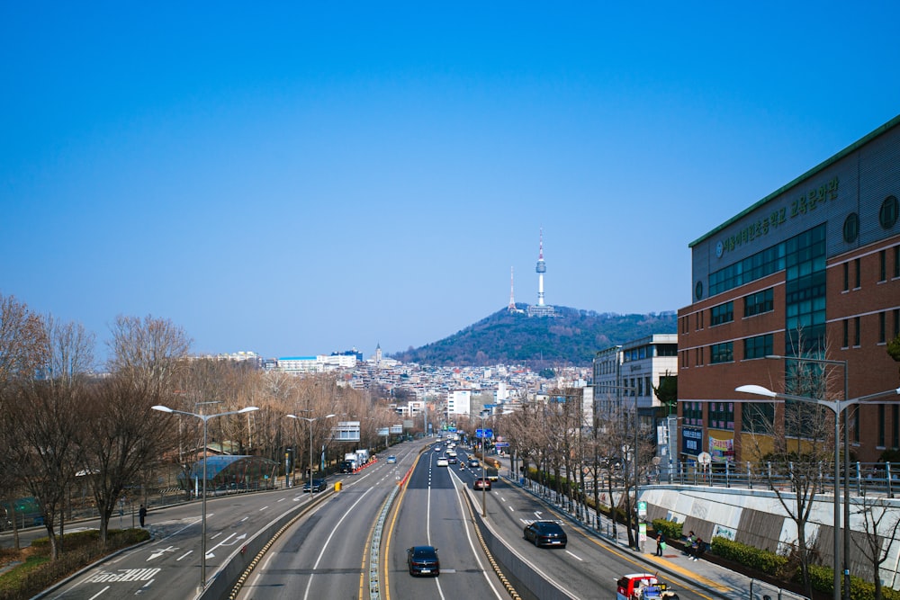 a view of a city street with a hill in the background
