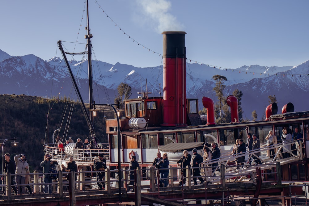 a group of people standing on a dock next to a boat