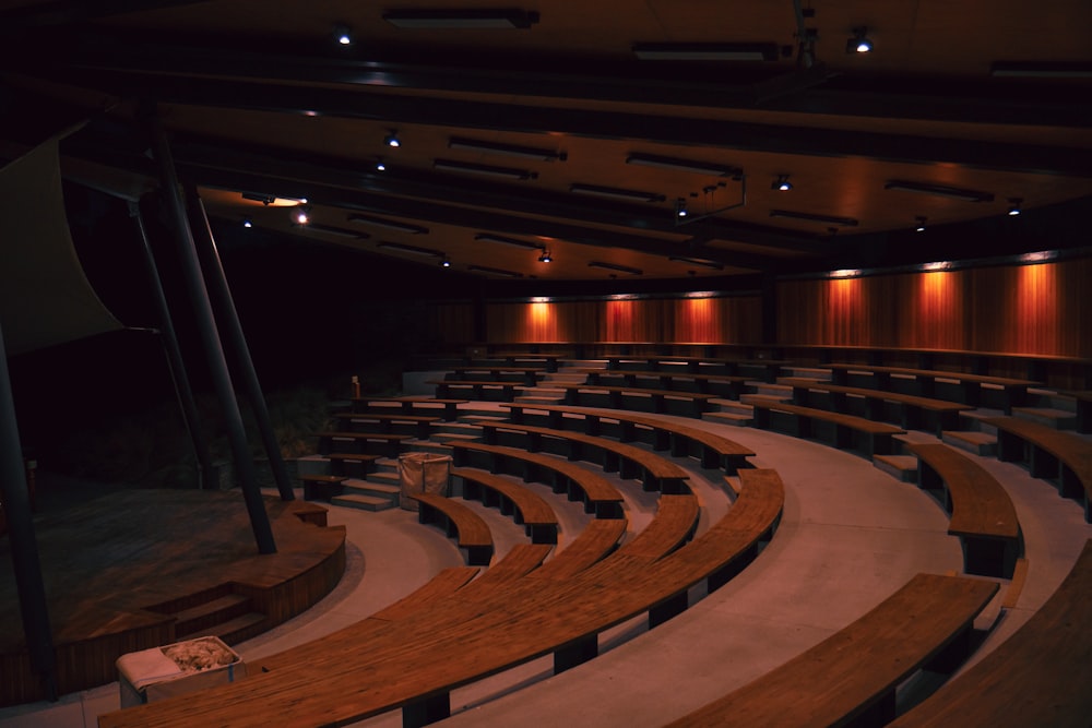 um grande auditório cheio de muitos assentos de madeira