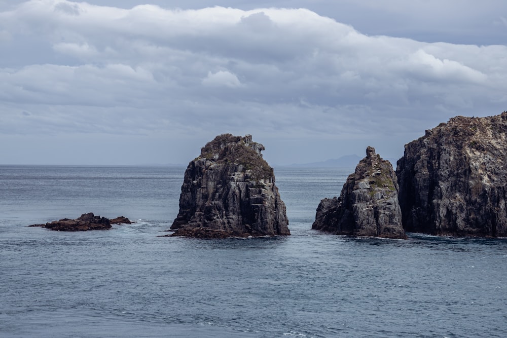 a group of rocks sitting in the middle of a body of water