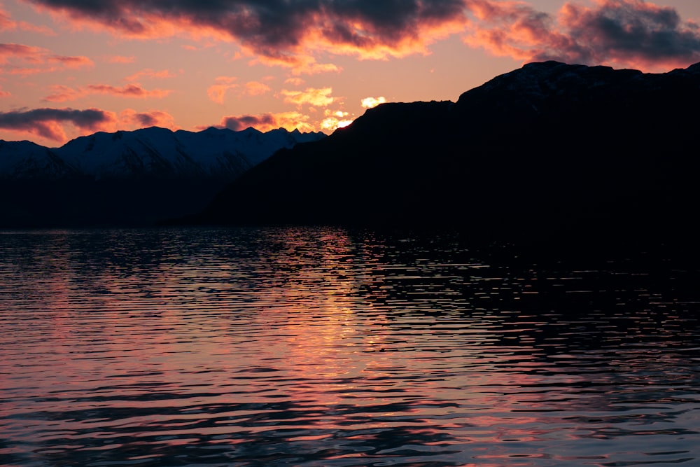 the sun is setting over a mountain range