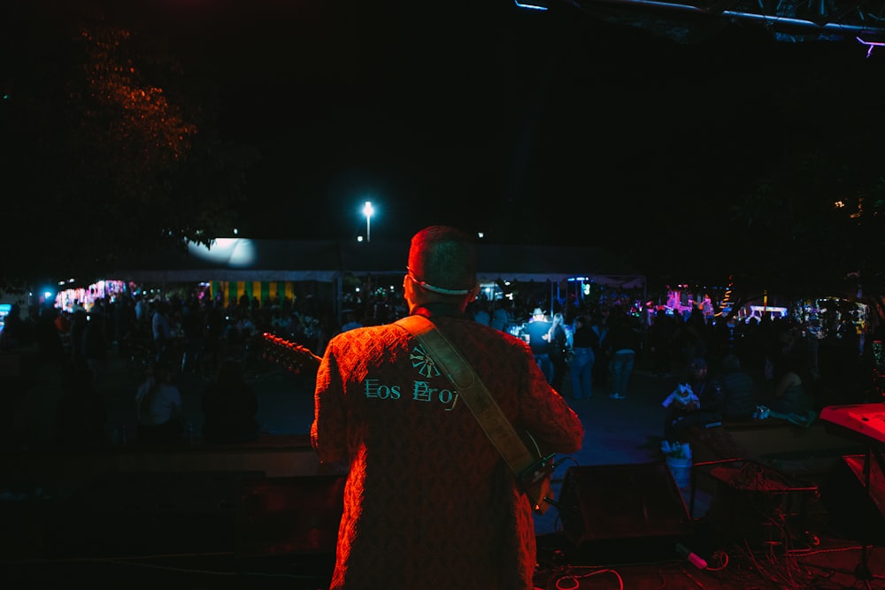 a man playing a guitar in front of a crowd