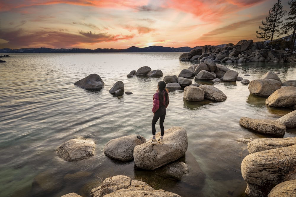 a person standing on rocks in the water