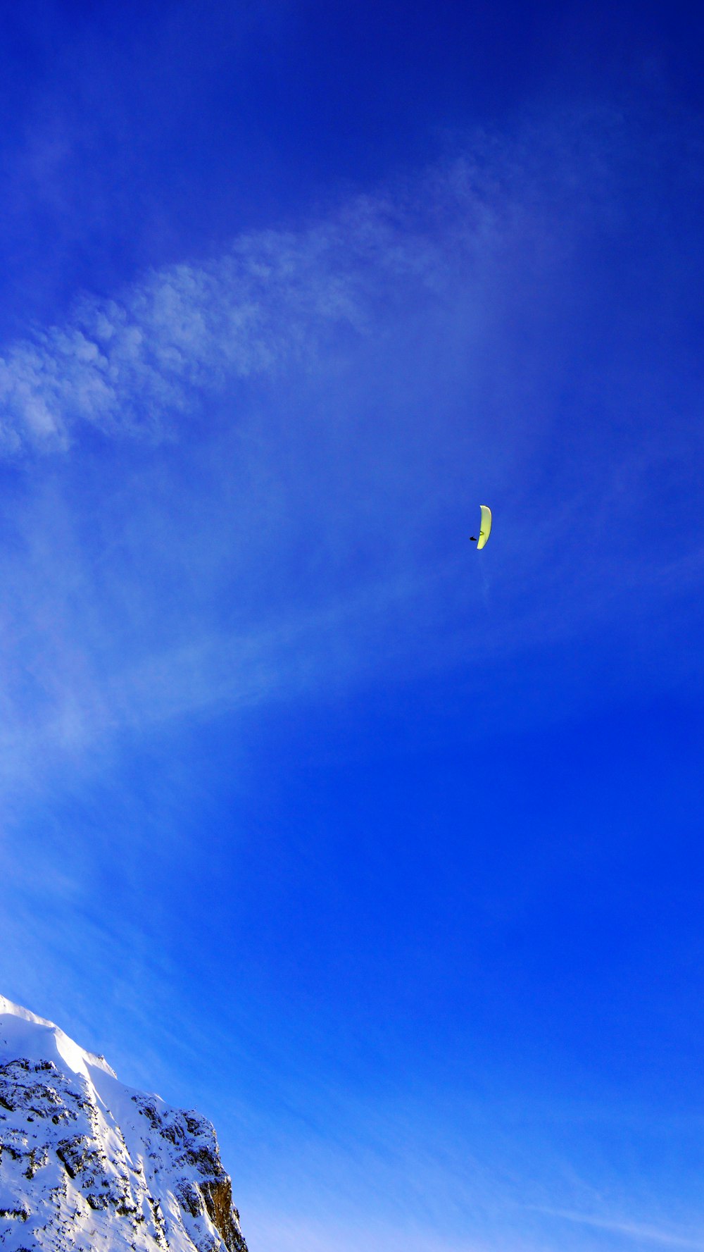 a person flying a kite on a snowy mountain