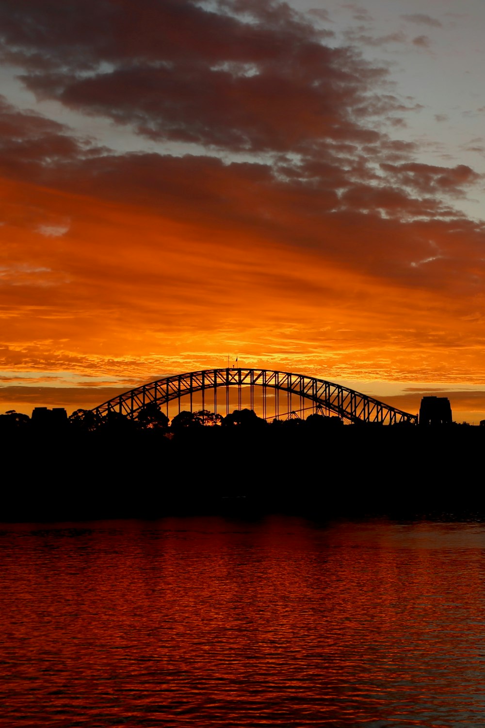 a bridge over a body of water at sunset