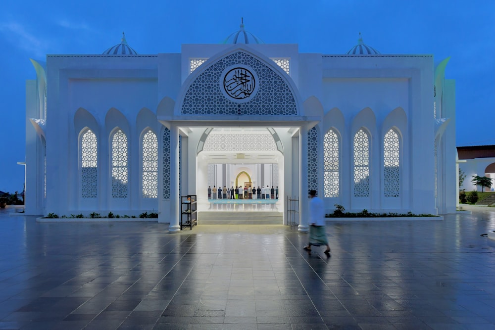 a person walking in front of a white building