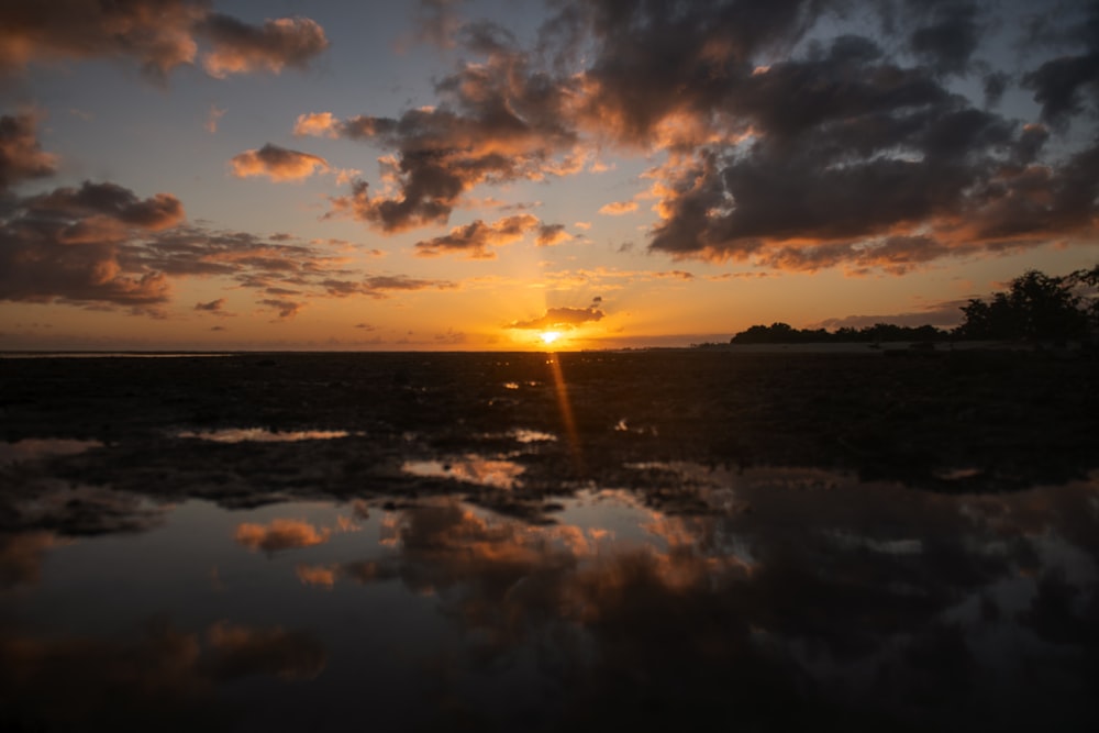 il sole sta tramontando su uno specchio d'acqua