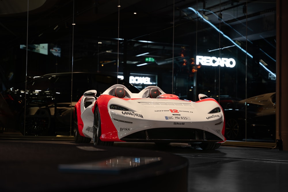 a red and white race car parked in front of a building