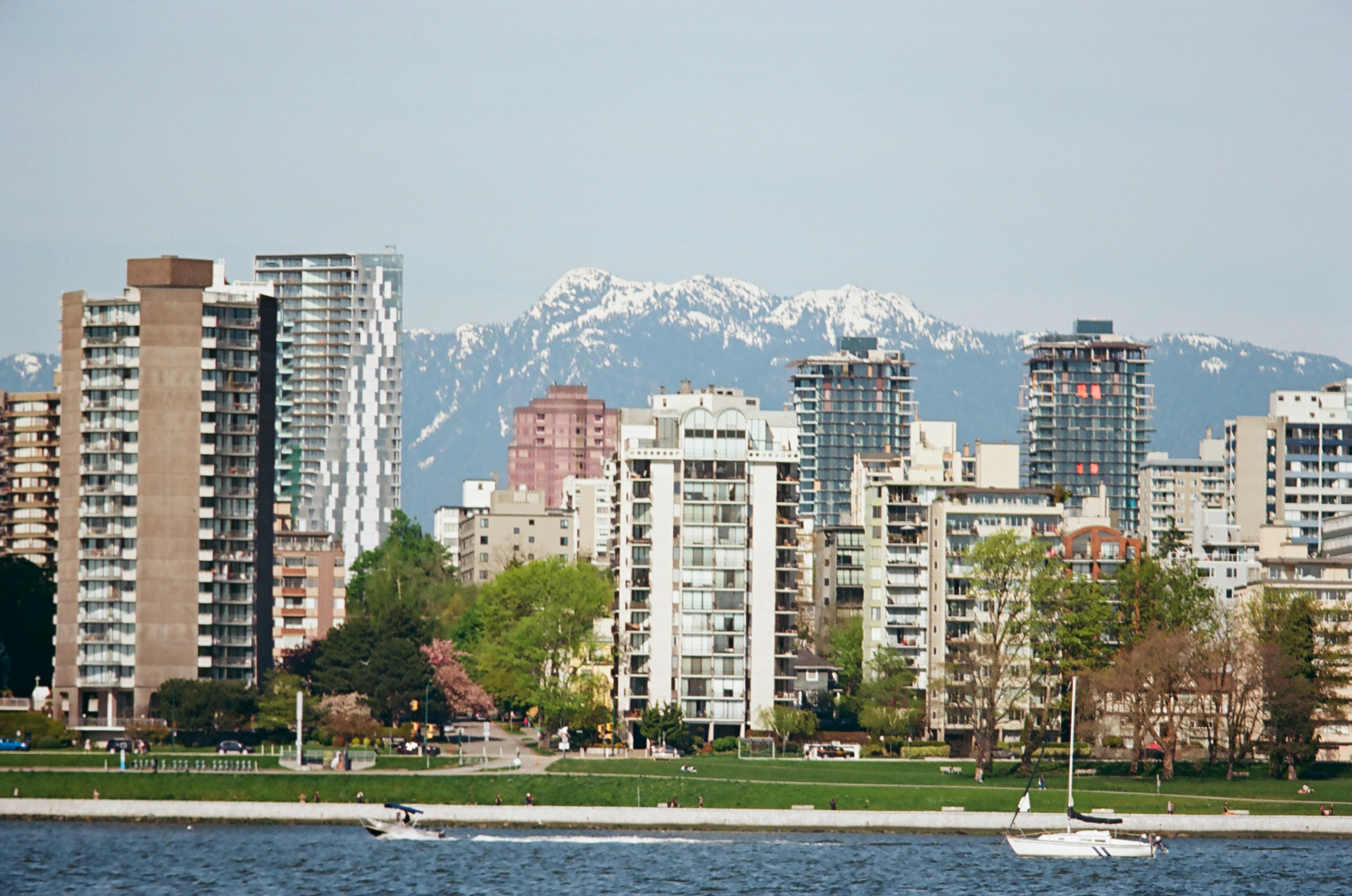 Scenic view of Vancouver Waterfront neighborhood showing modern apartments with mountain backdrop - apartments for remote workers