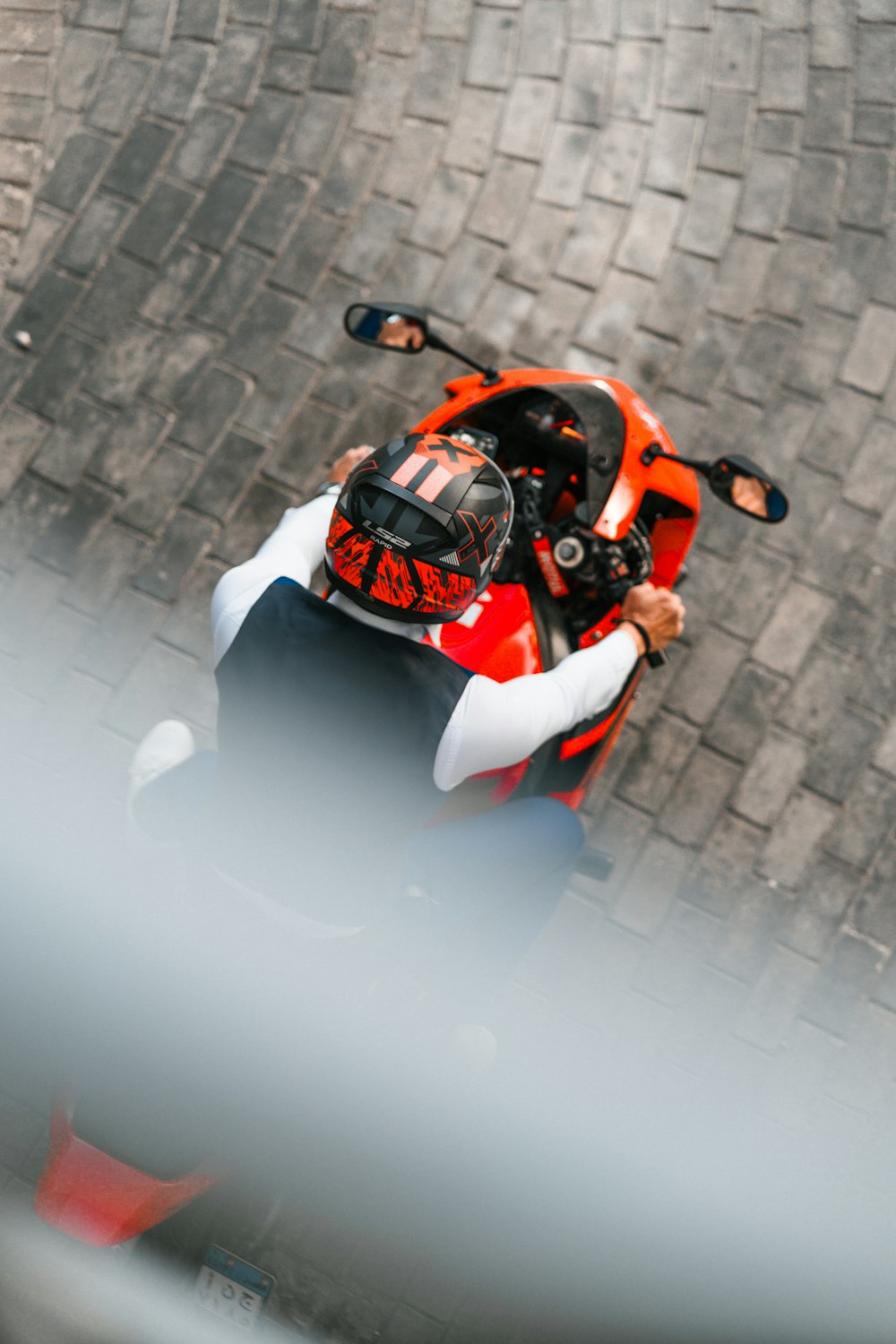 a person riding a motorcycle on a brick road