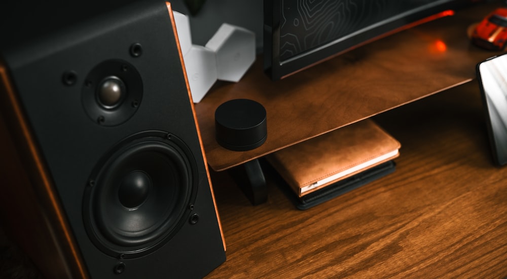 a wooden desk with speakers and a laptop on it