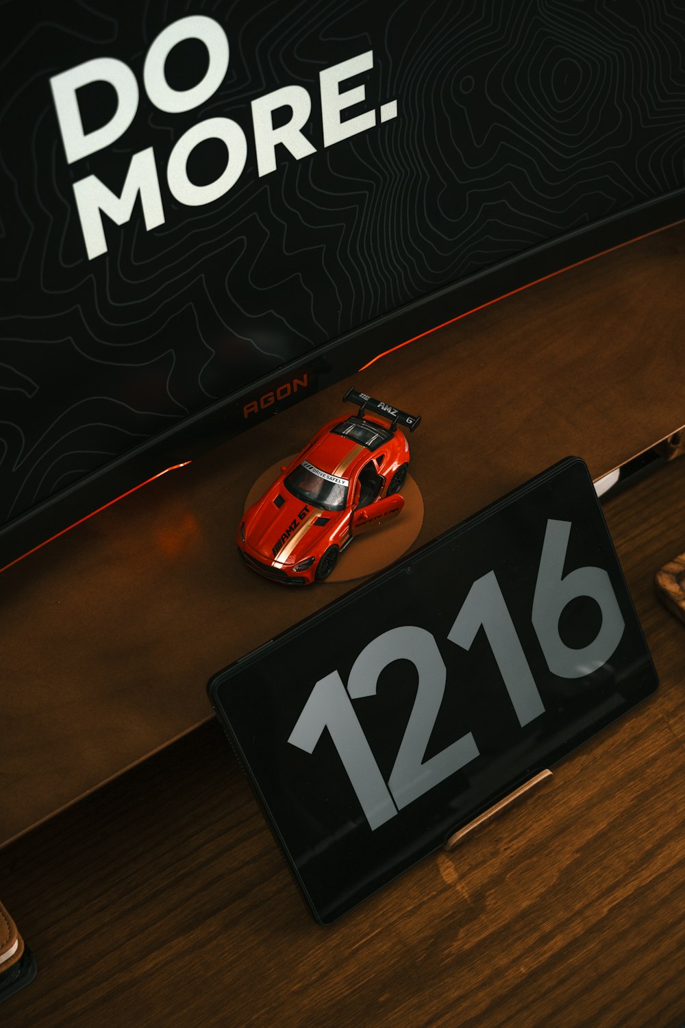 a red car sitting on top of a wooden desk