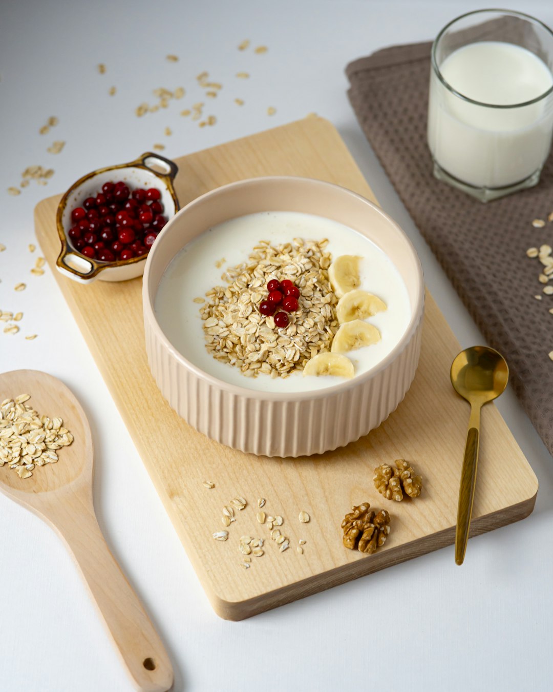 a bowl of oatmeal with a spoon and a glass of milk