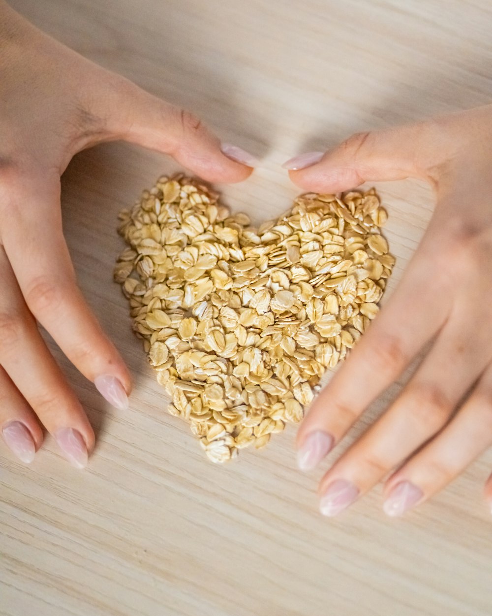 two hands holding a heart shaped oatmeal