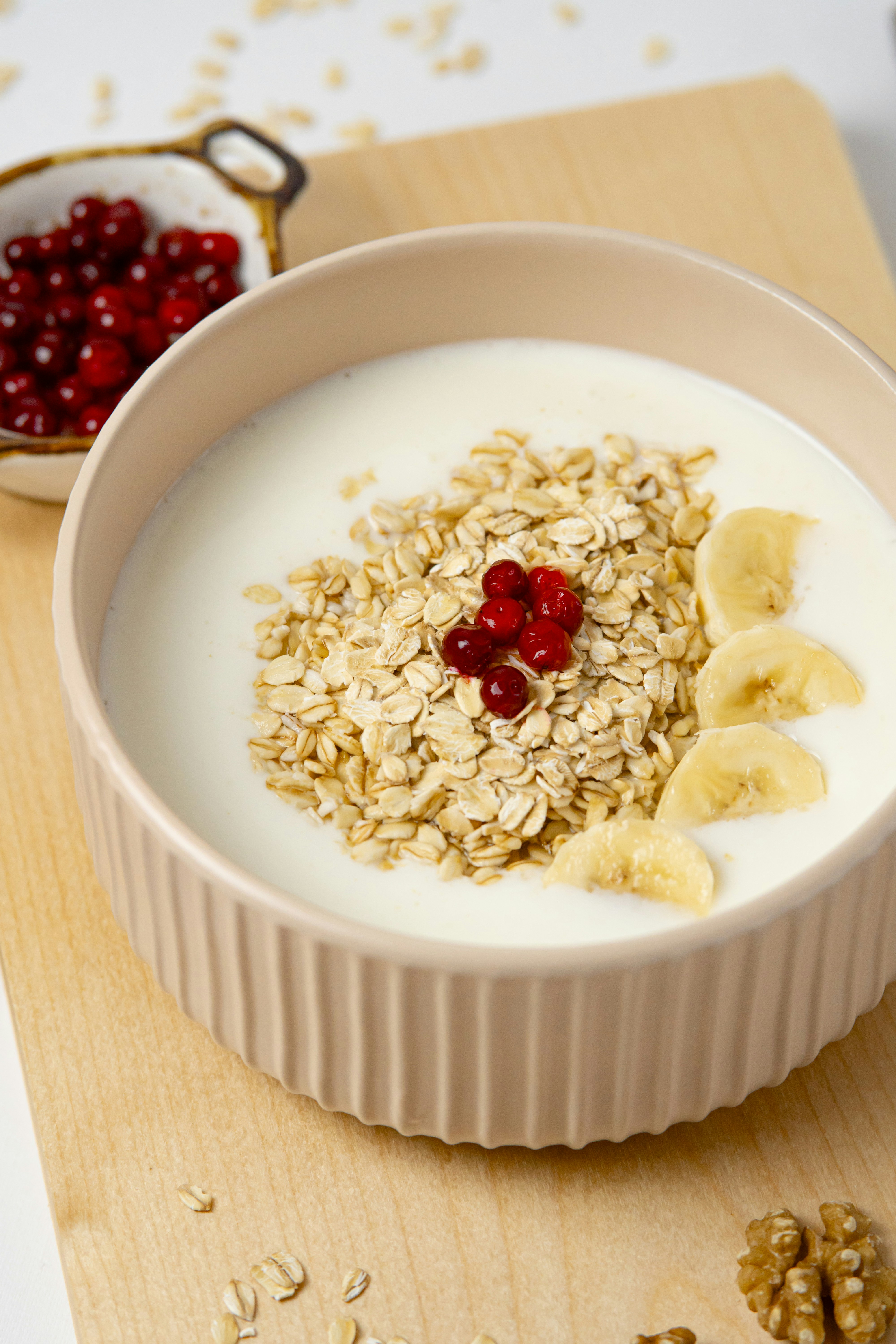 a bowl of oatmeal with banana slices and cherries