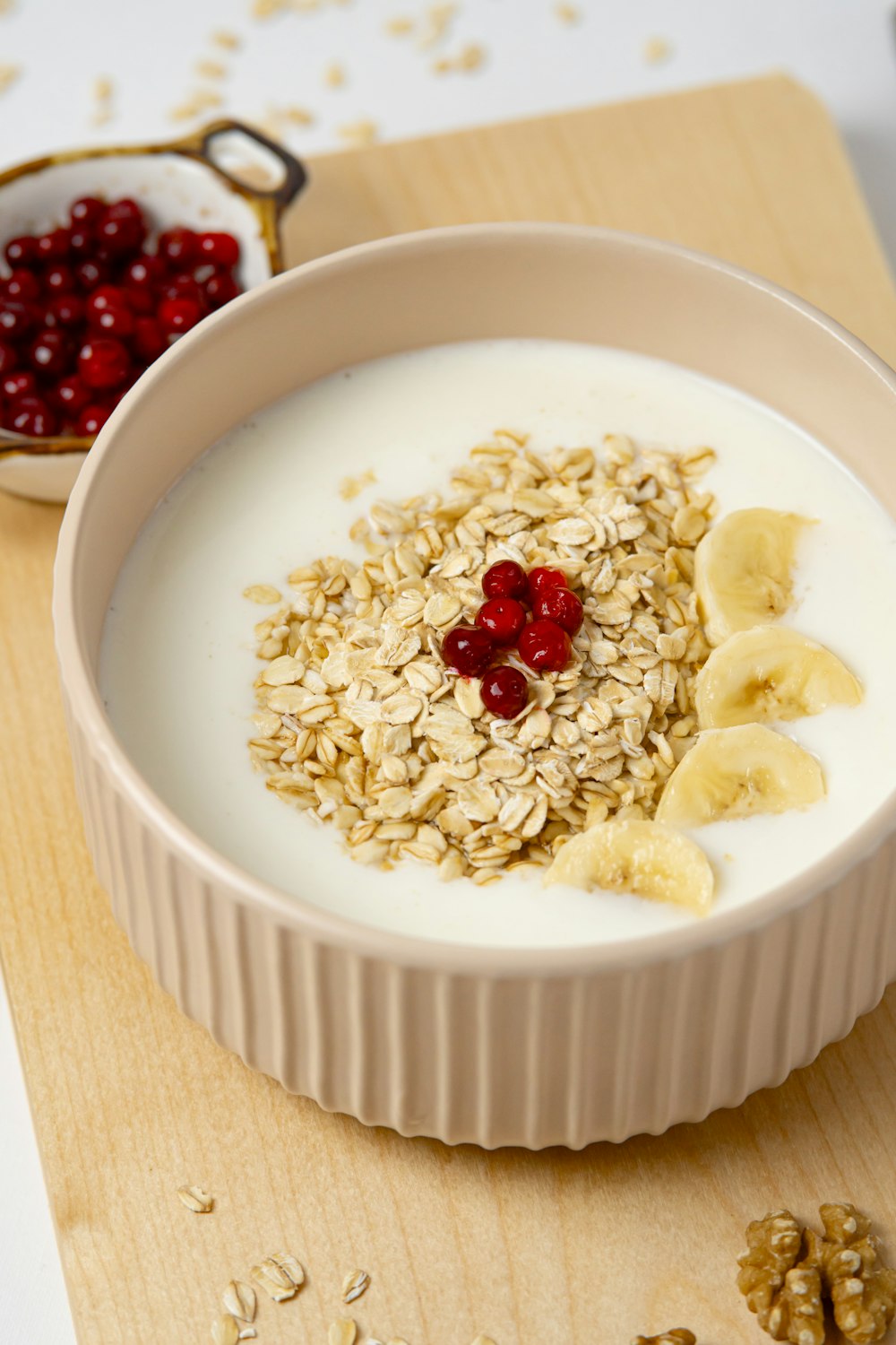 a bowl of oatmeal with banana slices and cherries