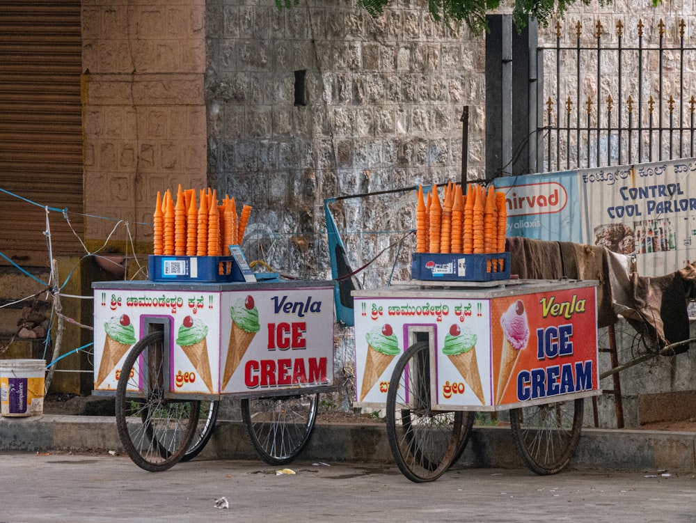 a couple of ice cream carts sitting on the side of a road