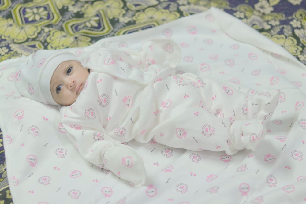 a baby wrapped in a blanket on a bed