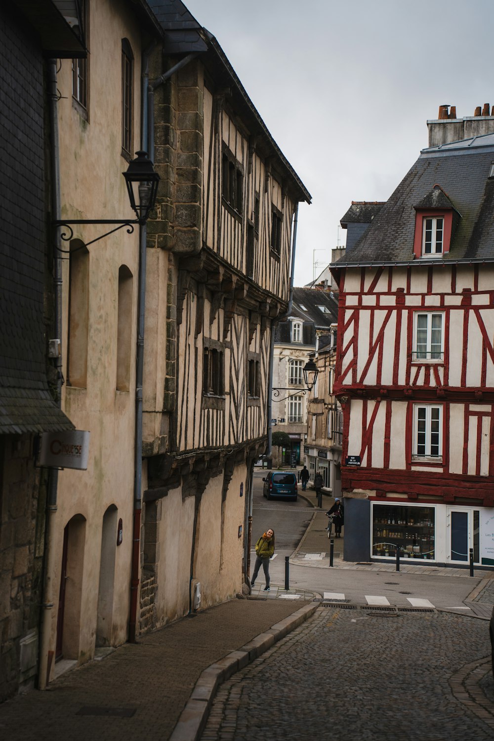 a man is walking down a cobblestone street