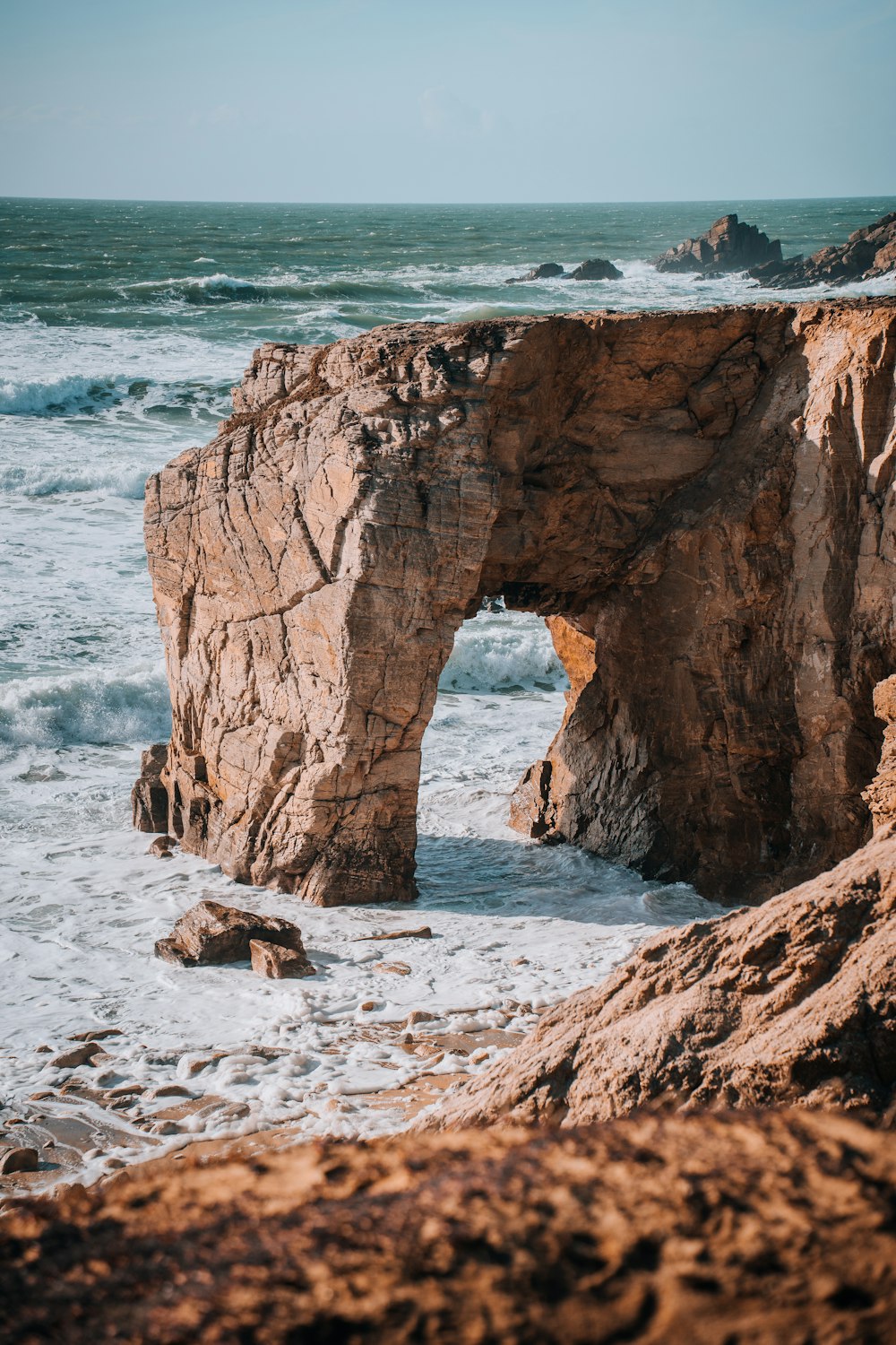 a rocky cliff with a hole in the middle of it