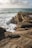 a person standing on top of a rocky cliff next to the ocean