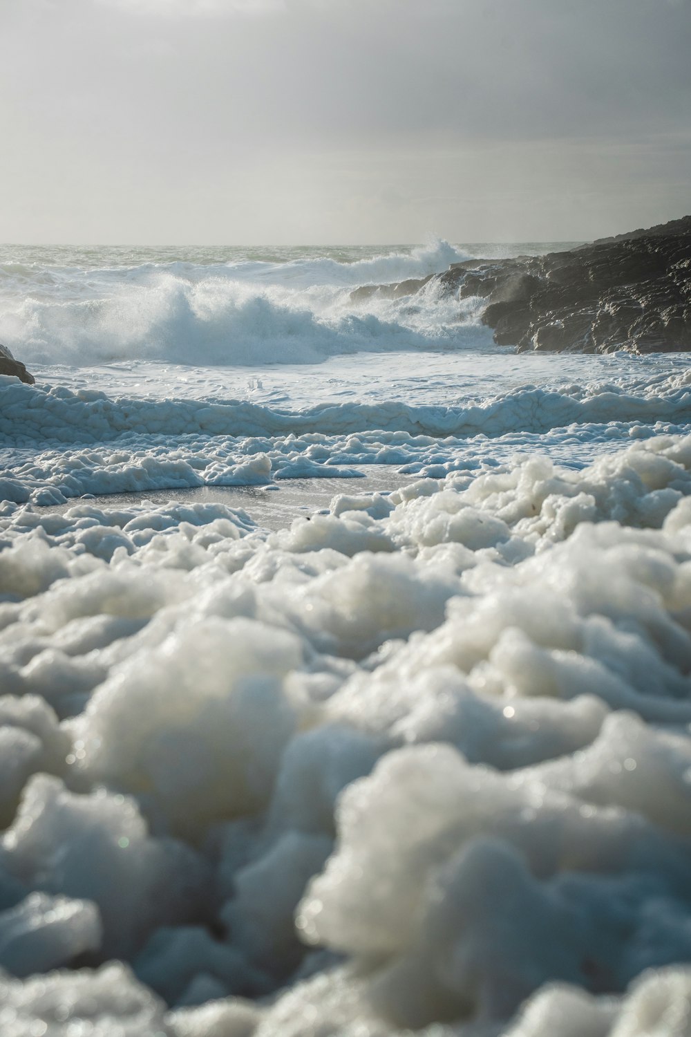 Une plage couverte d’écume au bord de l’océan