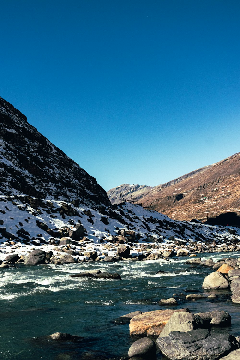 ein Fluss, der durch einen schneebedeckten Berghang fließt