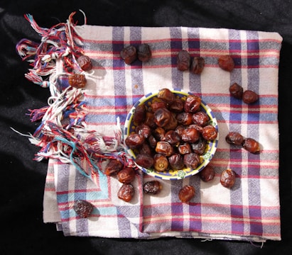 a bowl of dates sitting on top of a checkered cloth