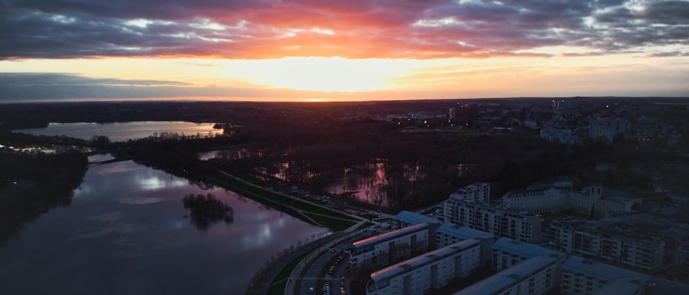 the sun is setting over a river and a city