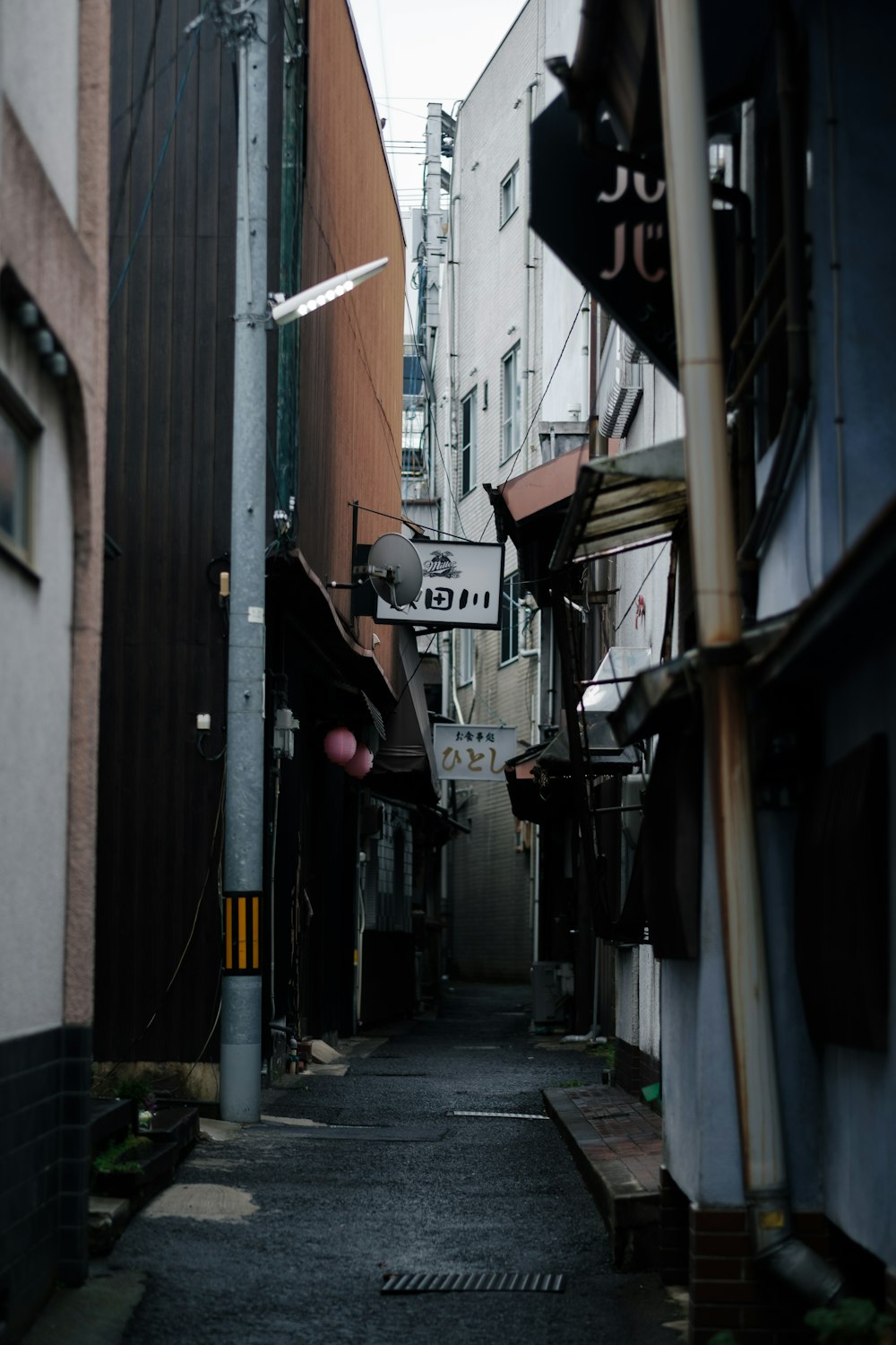 a narrow alley way with buildings and signs