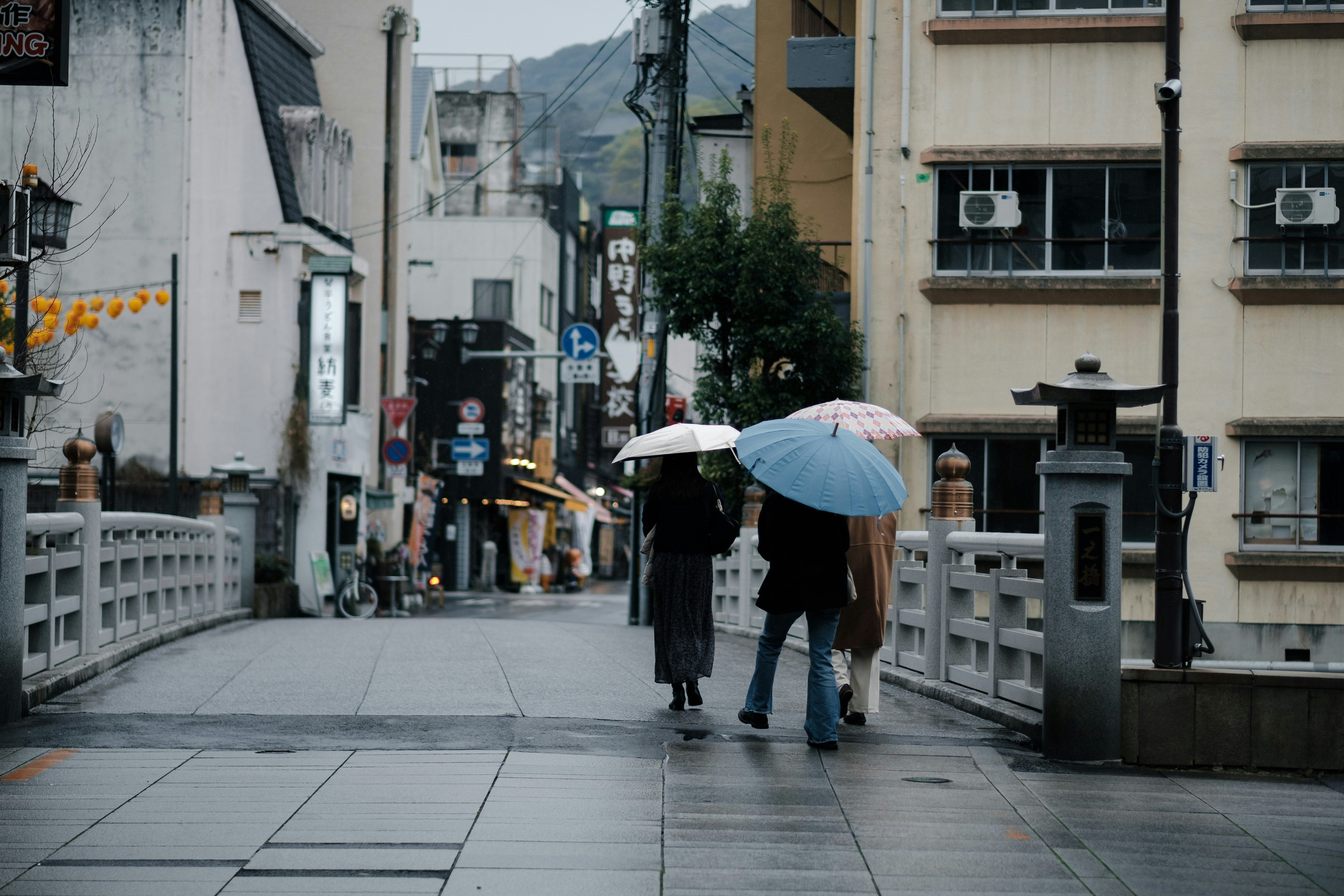 傘をさして雨の日を過ごす親子のイメージ