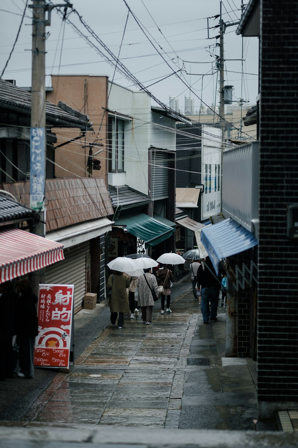 a group of people walking down a street holding umbrellas