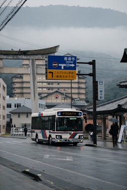 a bus driving down a street next to a tall building