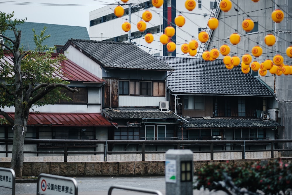 a group of orange lanterns hanging from the roof of a building