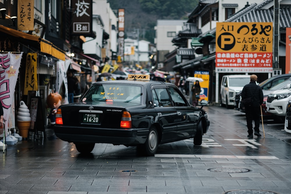 a taxi cab driving down a street next to tall buildings