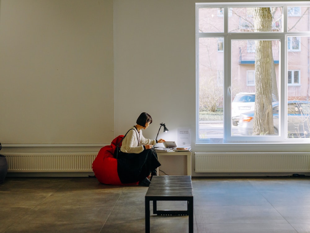 a woman sitting on a bench in front of a window