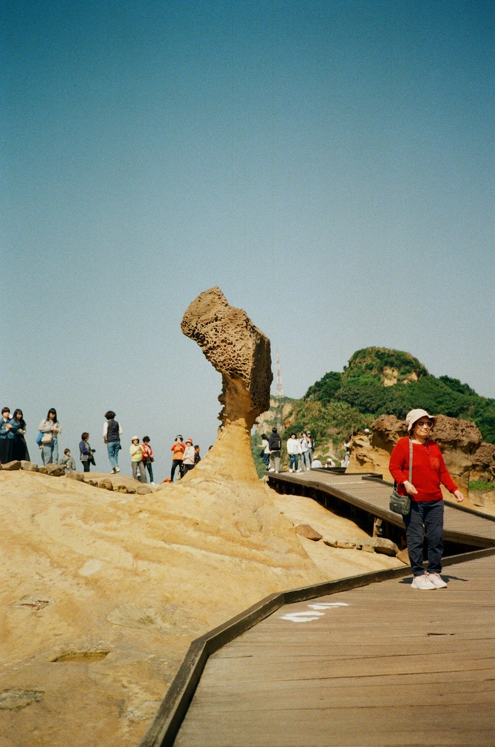 a group of people standing around a large rock formation