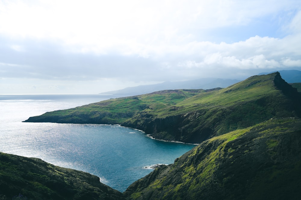 a large body of water surrounded by lush green hills