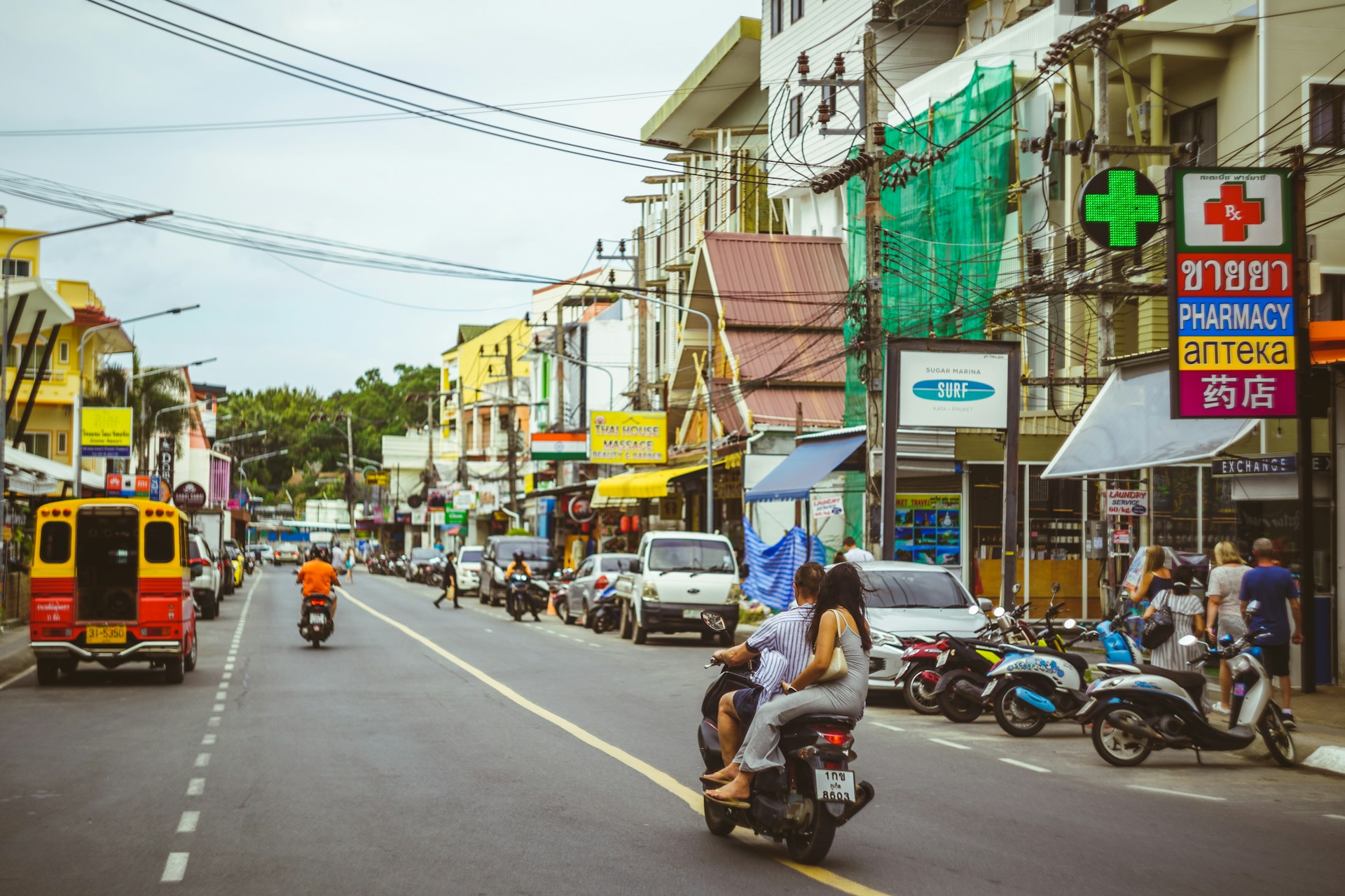 a group of people riding scooters down a street