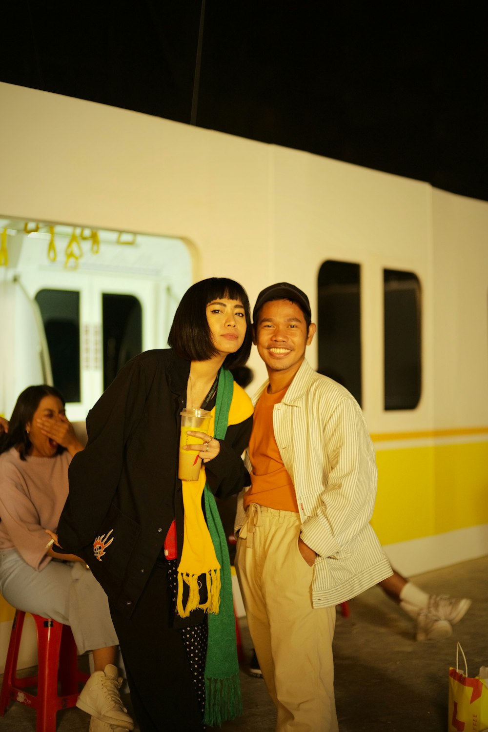 a man and woman standing next to each other in front of a train